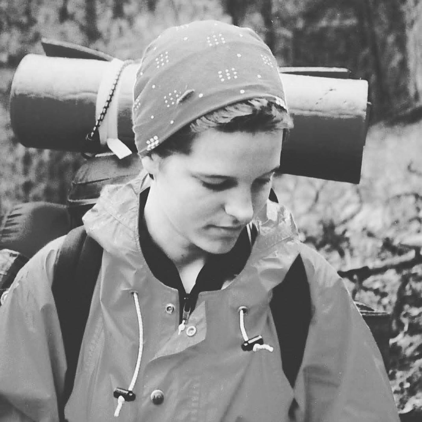 Lorca as a teenager on a backpacking trail, head bowed under a heavy pack