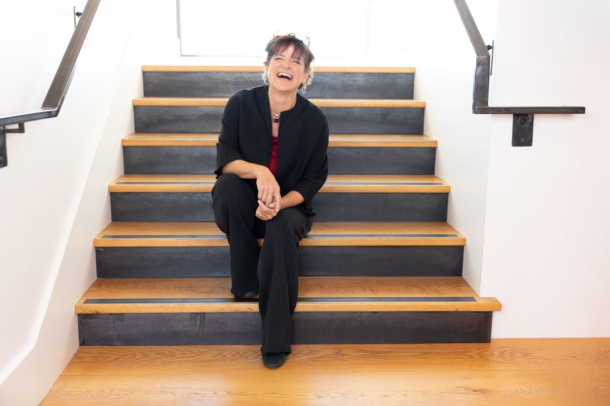 Lorca sitting on a staircase in an office building, laughing
